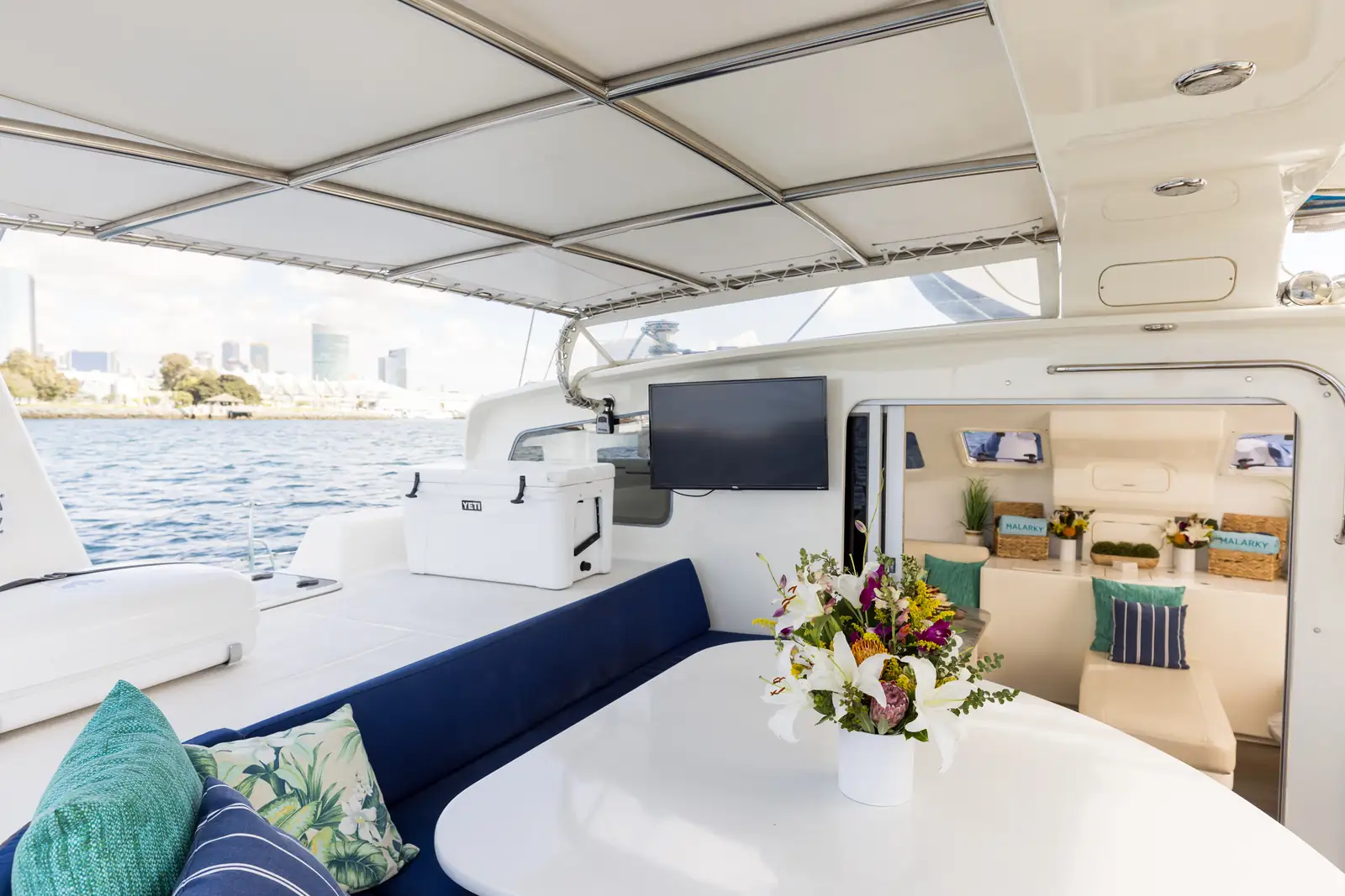 Malarky's aft deck staged for BYOB charters. Yeti cooler, cockpit seating, and indoor lounge beyond
