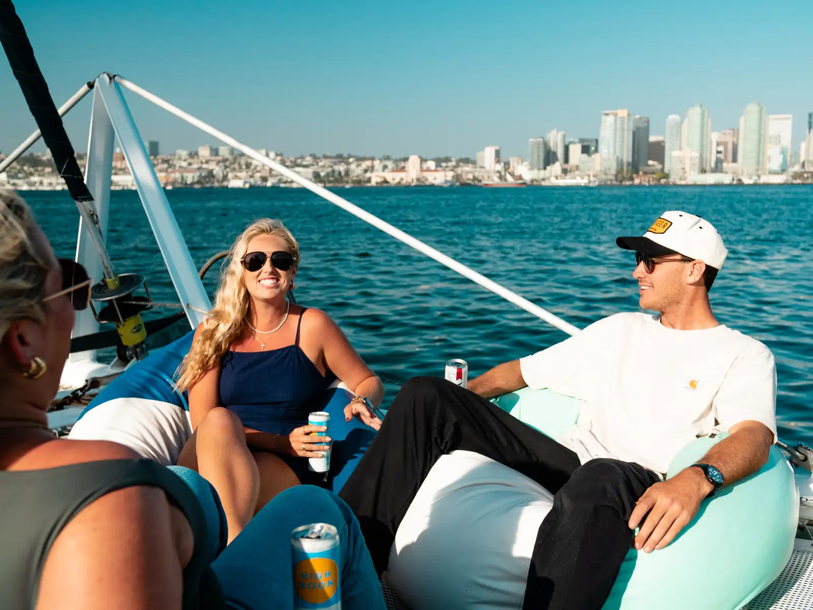Guests lounging with BYOB drinks on Malarky's aft deck with San Diego skyline behind