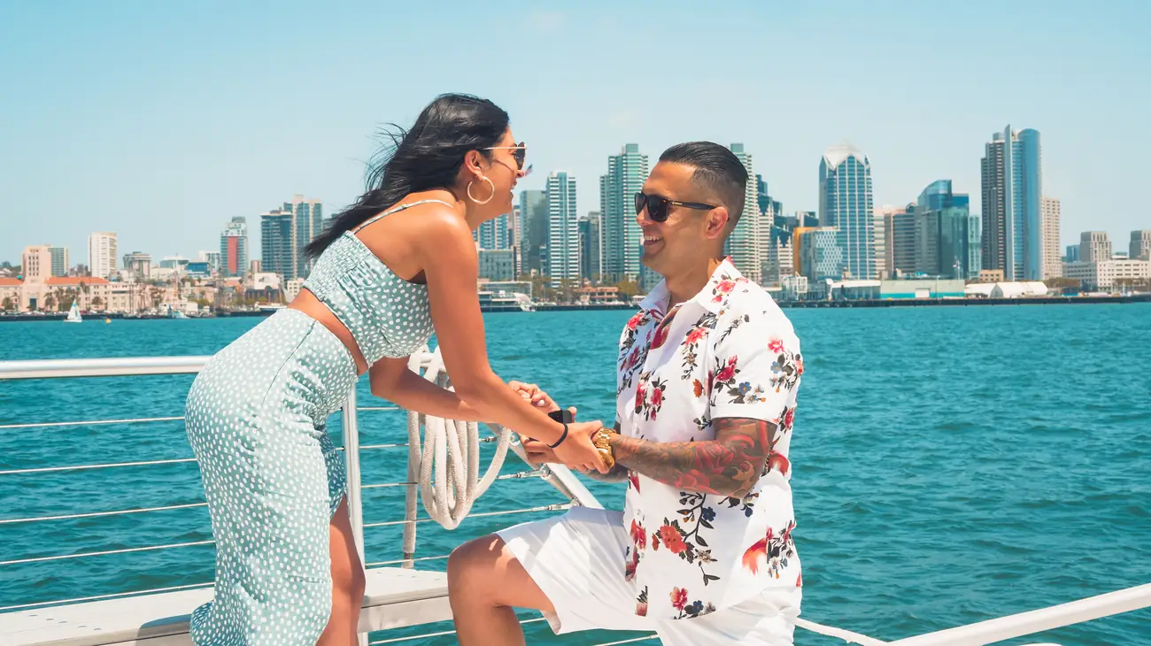 Marriage proposal on Malarky's deck with downtown San Diego skyline behind